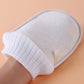 Natural loofah bath glove angled view with ribbed white cuff and textured beige pad