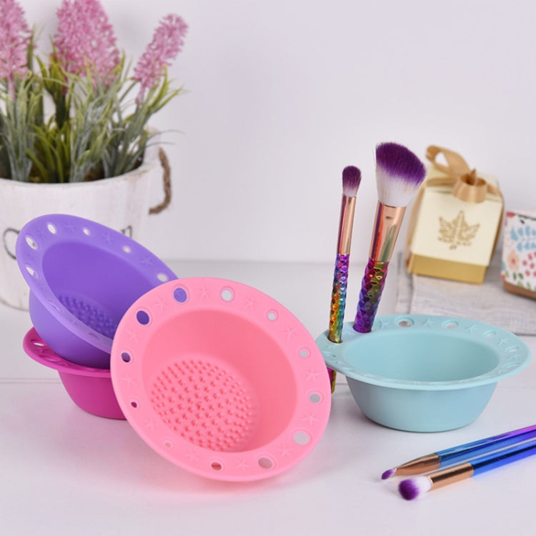 Silicone makeup brush cleaning bowls in purple, pink, and blue with textured scrubbing pads.