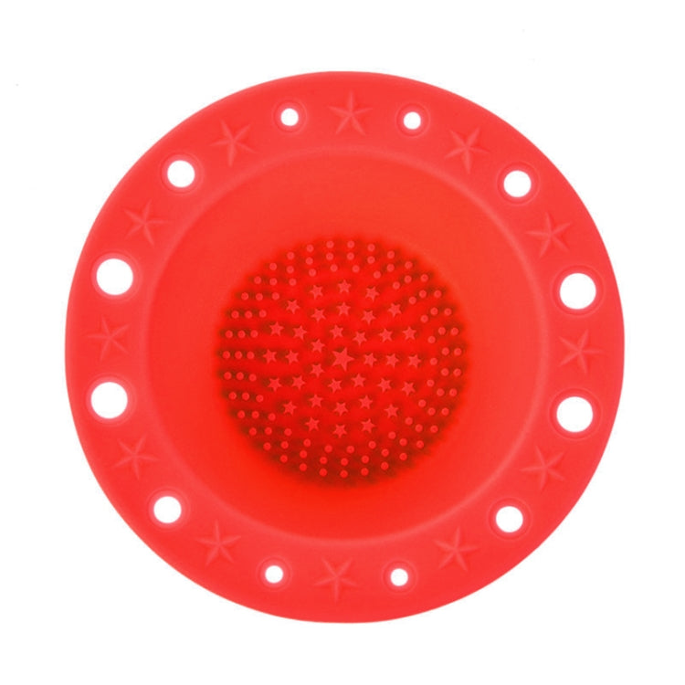 Red silicone makeup brush cleaning bowl with central textured scrubbing pad and rim holes.