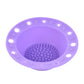 Lavender-purple silicone makeup brush cleaning bowl with textured scrubbing pad and rim holes.