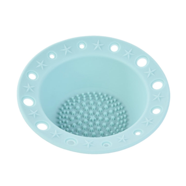 Light blue silicone makeup brush cleaning bowl with central textured scrubbing pad and rim holes.