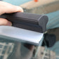 Black-and-white water scraper squeegee blade pressed to car window