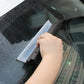 White blade with black housing water scraper removing droplets from car glass