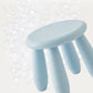 Light blue round plastic stool with curved seat and three taper legs