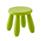 Green plastic children’s stool with a round seat and three short legs