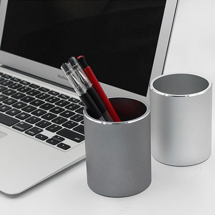 Silver/gray round metal pencil holder with black and red markers inside