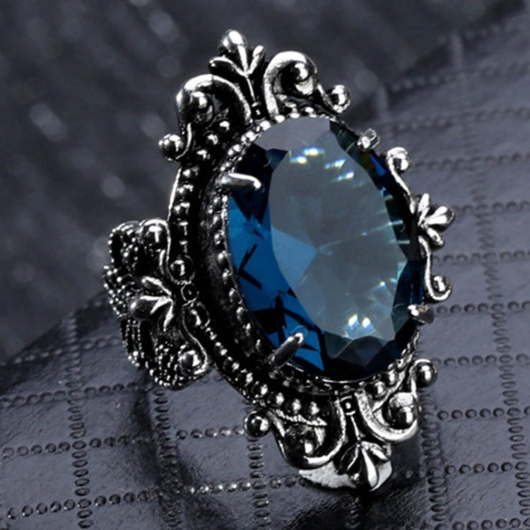 Silver-tone ornate ring with teardrop blue gemstone centerpiece, vintage filigree