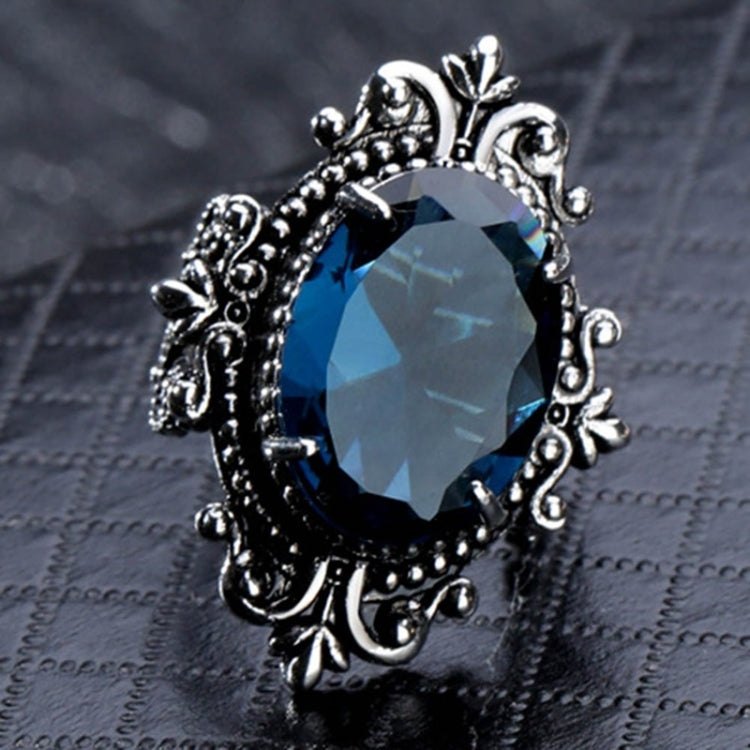 Vintage silver ring with oval blue gemstone and raised scroll filigree bezel
