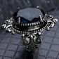 Silver-tone ring with dark-blue faceted oval gemstone and decorative beaded shoulders