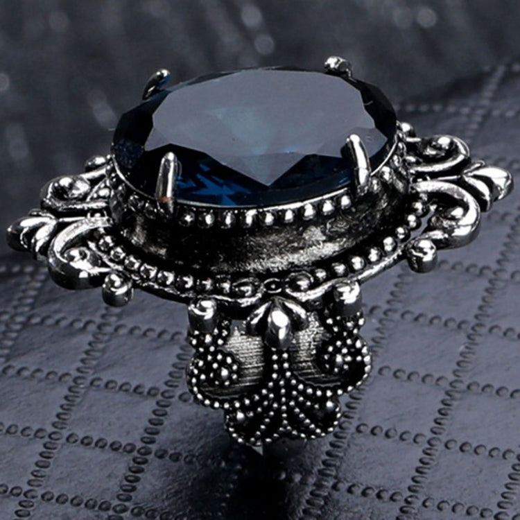 Silver-tone ring with dark-blue faceted oval gemstone and decorative beaded shoulders