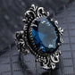 Vintage silver ring with blue teardrop gemstone and textured filigree band