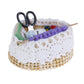 Mini dollhouse knitting tool basket with black scissors and purple yarn across white lace rim