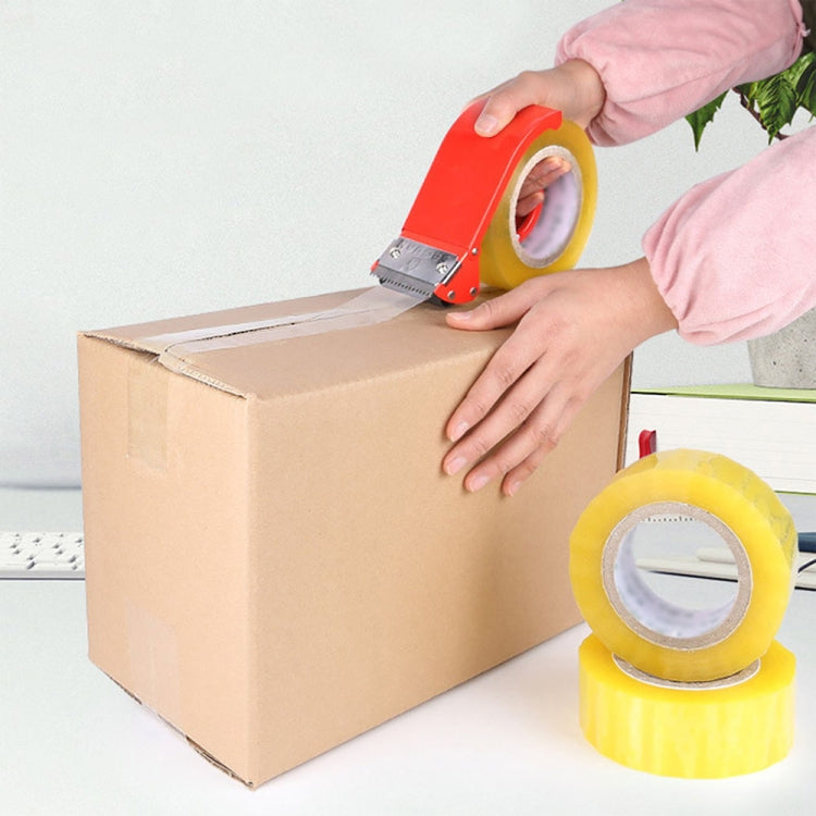 Hands using red tape sealer to apply tape across a cardboard box