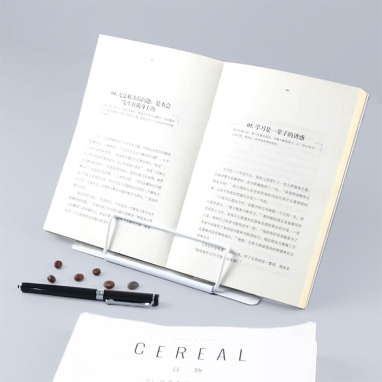 White metal adjustable book stand supporting an open book with page clip