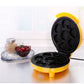Mini double-sided baking machine with yellow body and open black molds on countertop