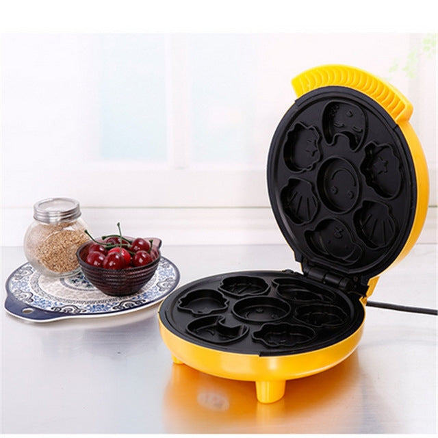 Mini double-sided baking machine with yellow body and open black molds on countertop