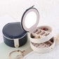 Open two-tier jewelry box showing earring slots and small ring organizer compartments.