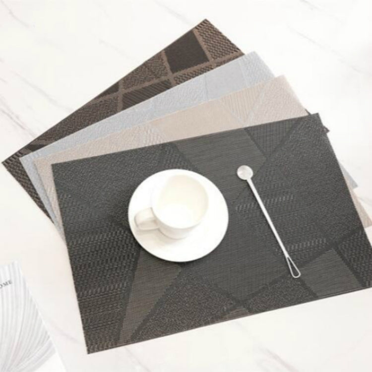 Dark gray table mat with geometric check pattern and a cup set on top.