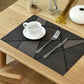 Dark gray textured table mat on a dining table with a white cup and saucer.