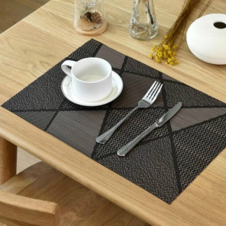 Dark gray textured table mat on a dining table with a white cup and saucer.