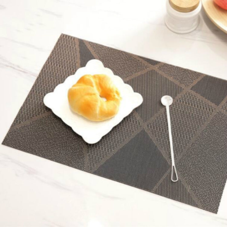 Dark gray geometric check table mat with a white scalloped plate and small spoon.