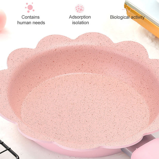 Pink nonstick milk pan interior with speckled coating and flower-shaped rim