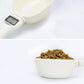 Cream electronic measuring spoon holding dry pet food, LCD display visible