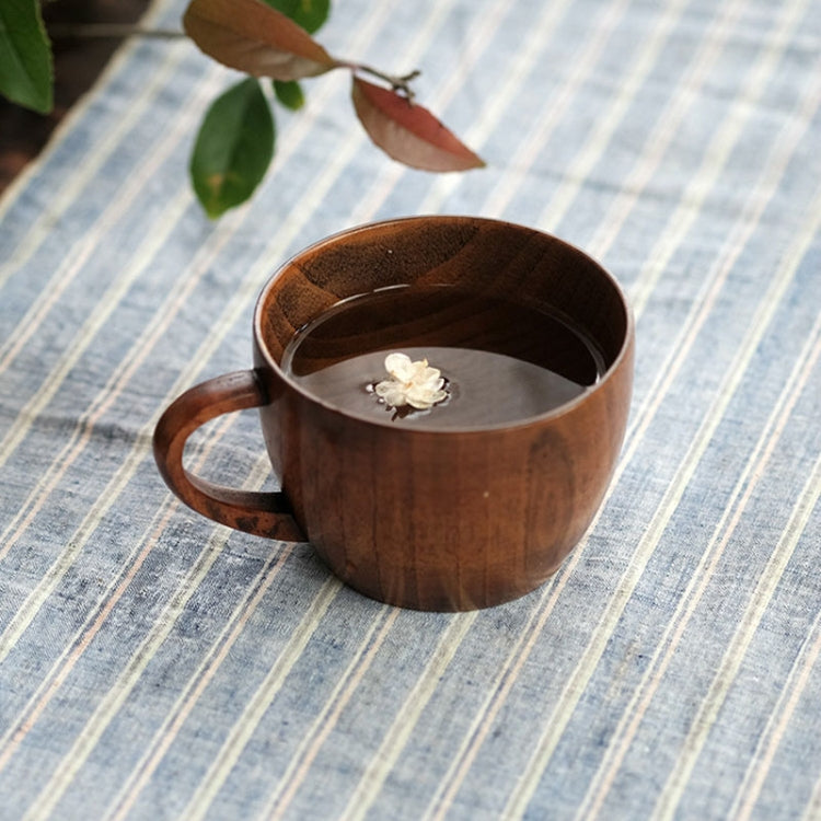 Brown wooden mug with handle, white flower detail near the bottom