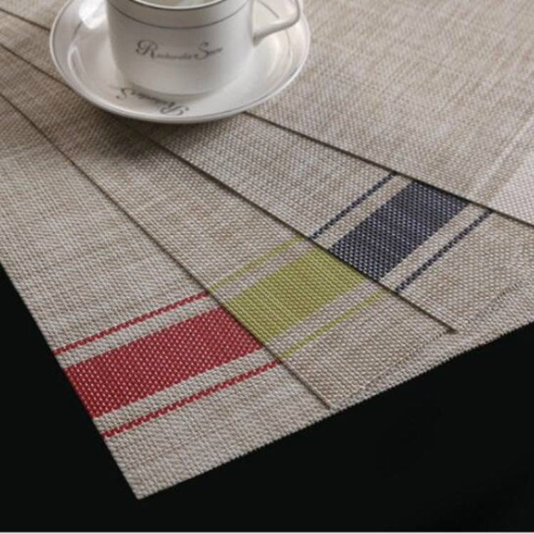 Braided PVC table mat with red, green, and navy stripe patches on beige