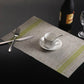 Braided PVC table mat with lime green stripe border and woven-style center, 30x45cm