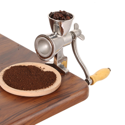 Stainless steel manual coffee grinder with wooden handle and hopper, on a tray
