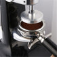 Coffee tamper press close-up with circular metal plate and powder chamber