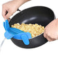 Blue silicone pot filter clip attached to a black skillet, straining cooked beans