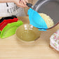 Blue silicone pot filter clip draining cooked pasta from a pan into a bowl