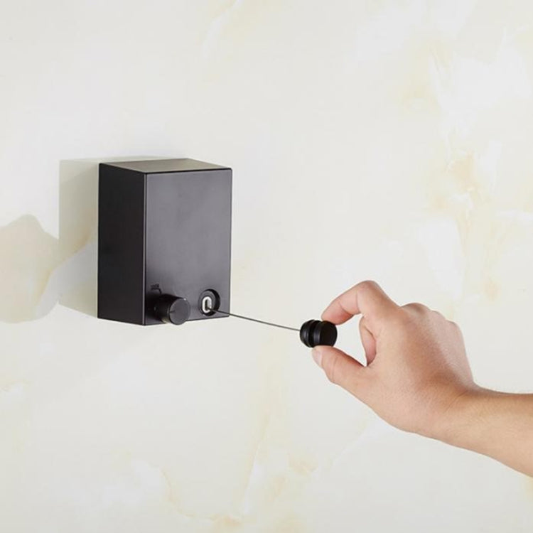 Retractable clothesline wall hanger being pulled out with wire from the black unit
