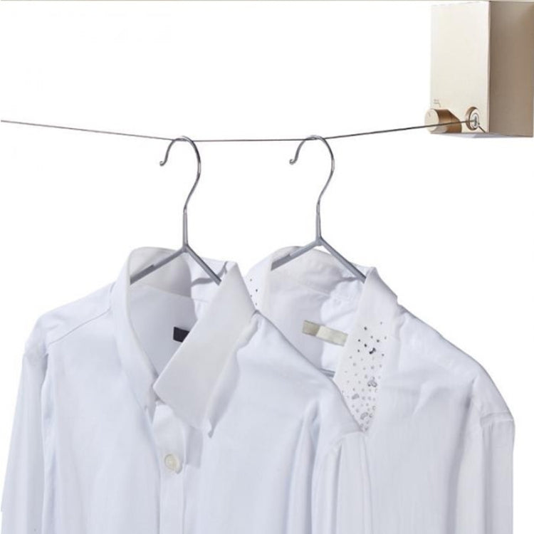 Retractable clothesline wire with two shirts hanging on metal hangers