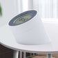 White alarm clock night light on a side table with circular LCD time display.
