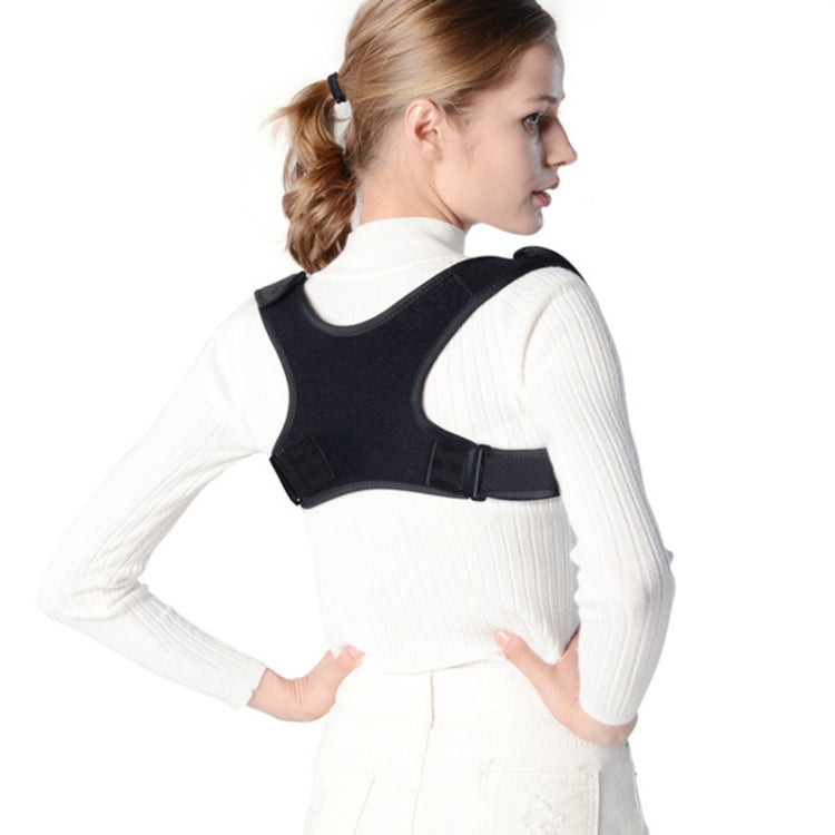 Black back correction strap over a white long-sleeve top, side view