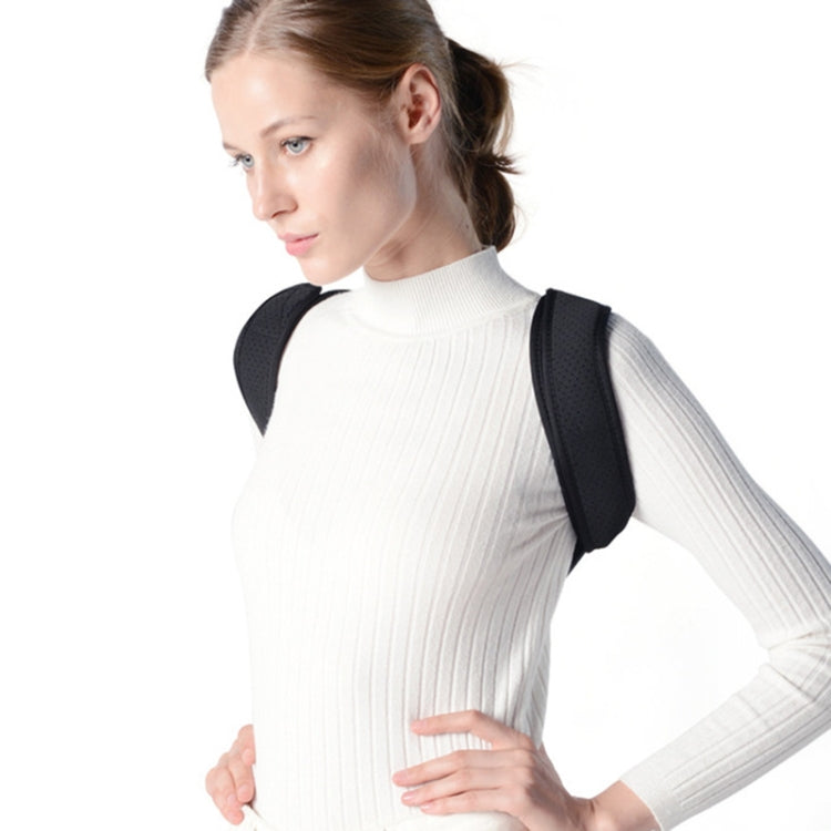 Black back correction strap with shoulder straps, worn over a white sweater