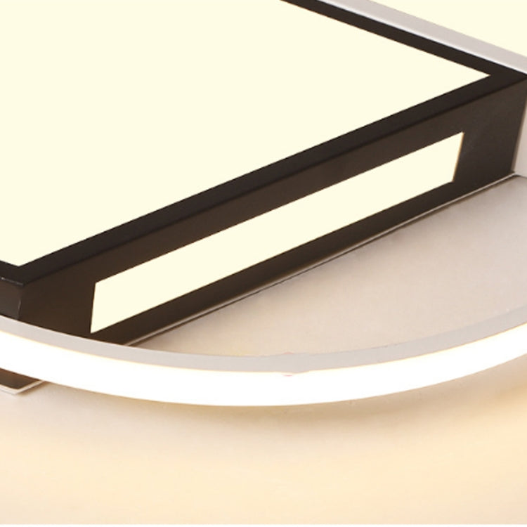 Ceiling lamp close-up with glowing warm light and black geometric inner bars