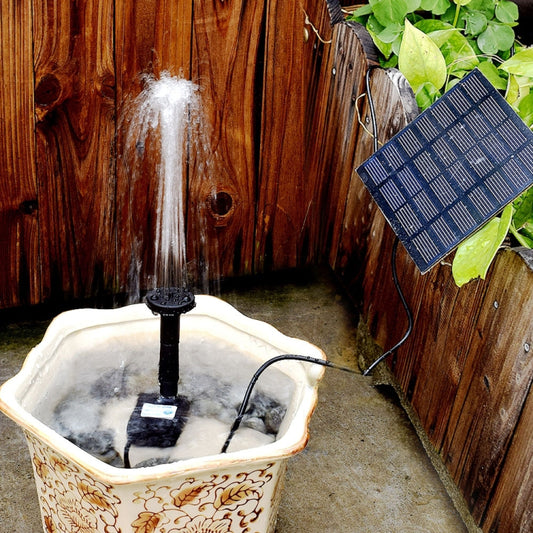 Solar fountain pump with waterfall spray over a decorative stone basin