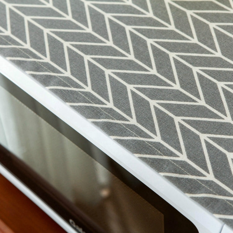 Close-up of dark gray microwave dust cover with white geometric arrow pattern