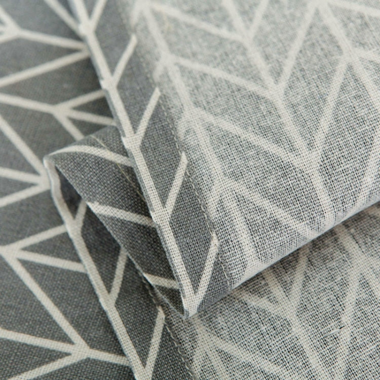 Textile close-up of microwave dust cover with dark gray and white arrow pattern