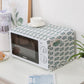 Microwave oven dust cover with white fabric and green leafy sprig print, pom trim