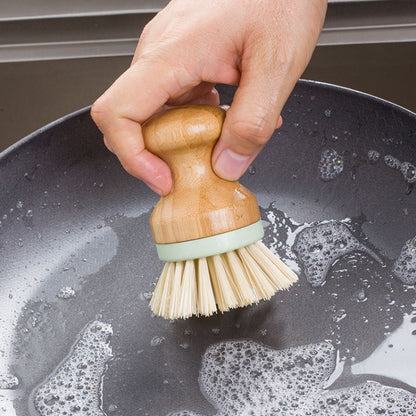 Dish scrubber brush with wooden handle, green band, cream bristles; hand grip