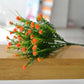 Orange simulation flower bouquet with small clustered blossoms and green stems