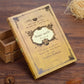 Yellow vintage pocket notebook, full cover view with gold-toned spell design and frame.