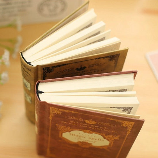 Vintage pocket notebook set with gold-toned covers, open pages showing inside sheets.