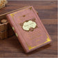 Pink vintage pocket notebook with ornate gold spell text and decorative border cover.