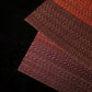 Close-up of burgundy red textured table cup mat fabric weave
